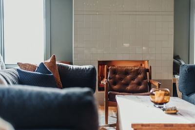 Lounge area with dark sofa, wooden furniture at The Stonebreaker Hotel