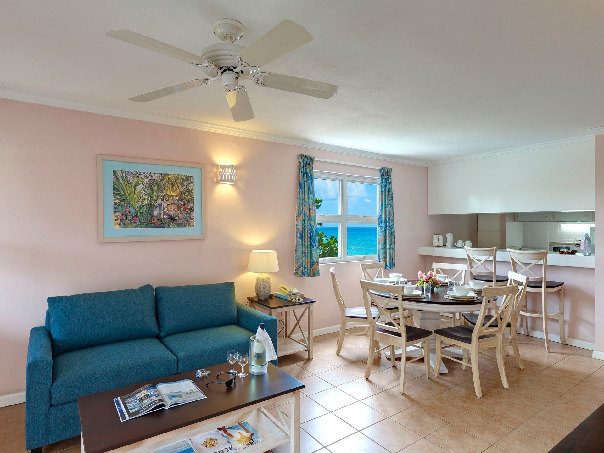 Deluxe Two Bedroom Apartment, Island View, featuring blue sofa with wall art and dining table at Butterfly Beach Hotel