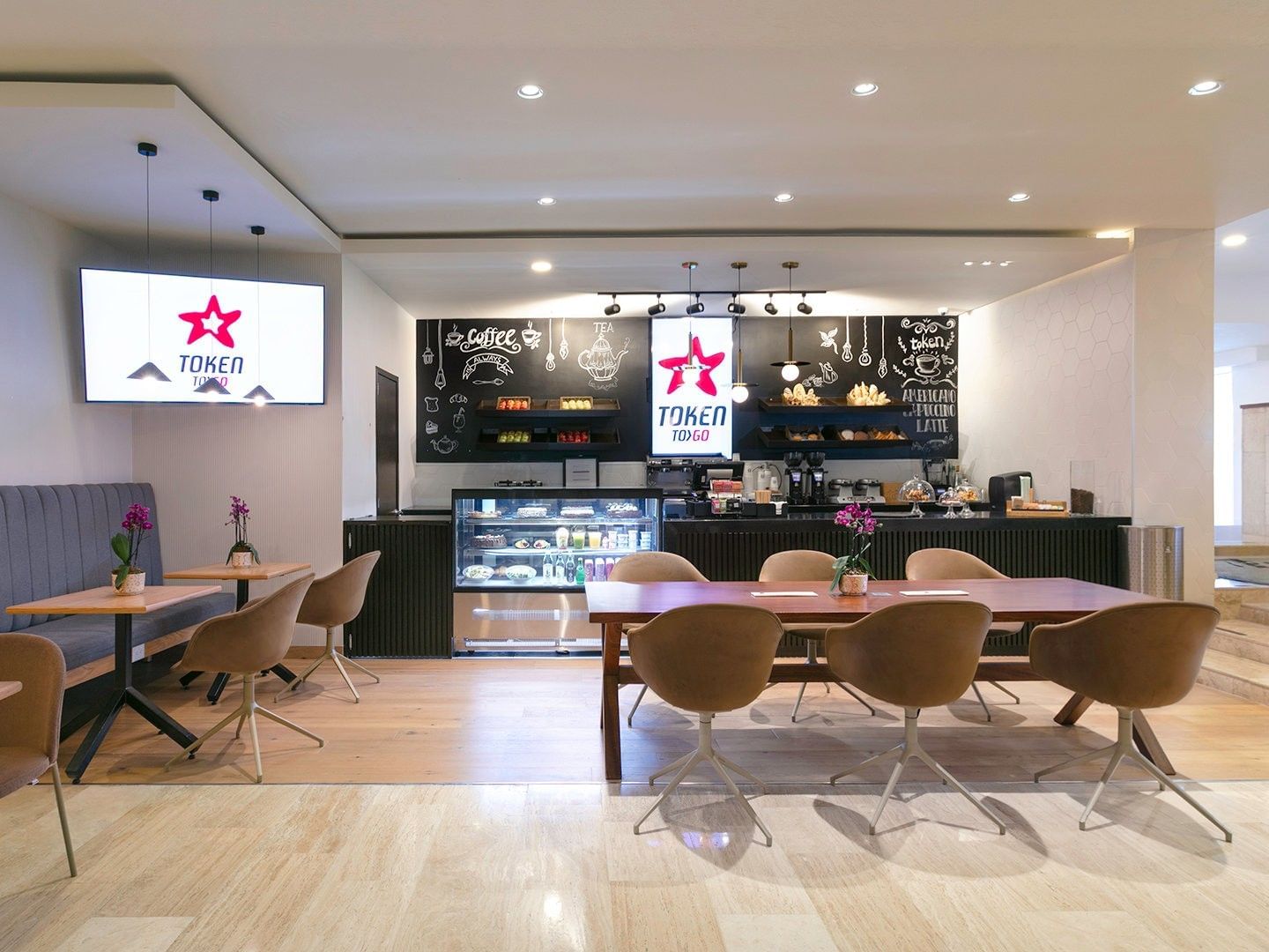 Token Cafe interior with wooden tables and a chalk art menu board at Camino Real Aeropuerto Mexico
