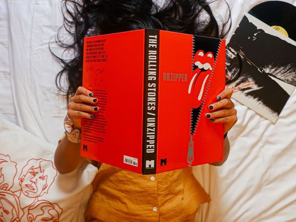 A person reading a Rolling Stones book