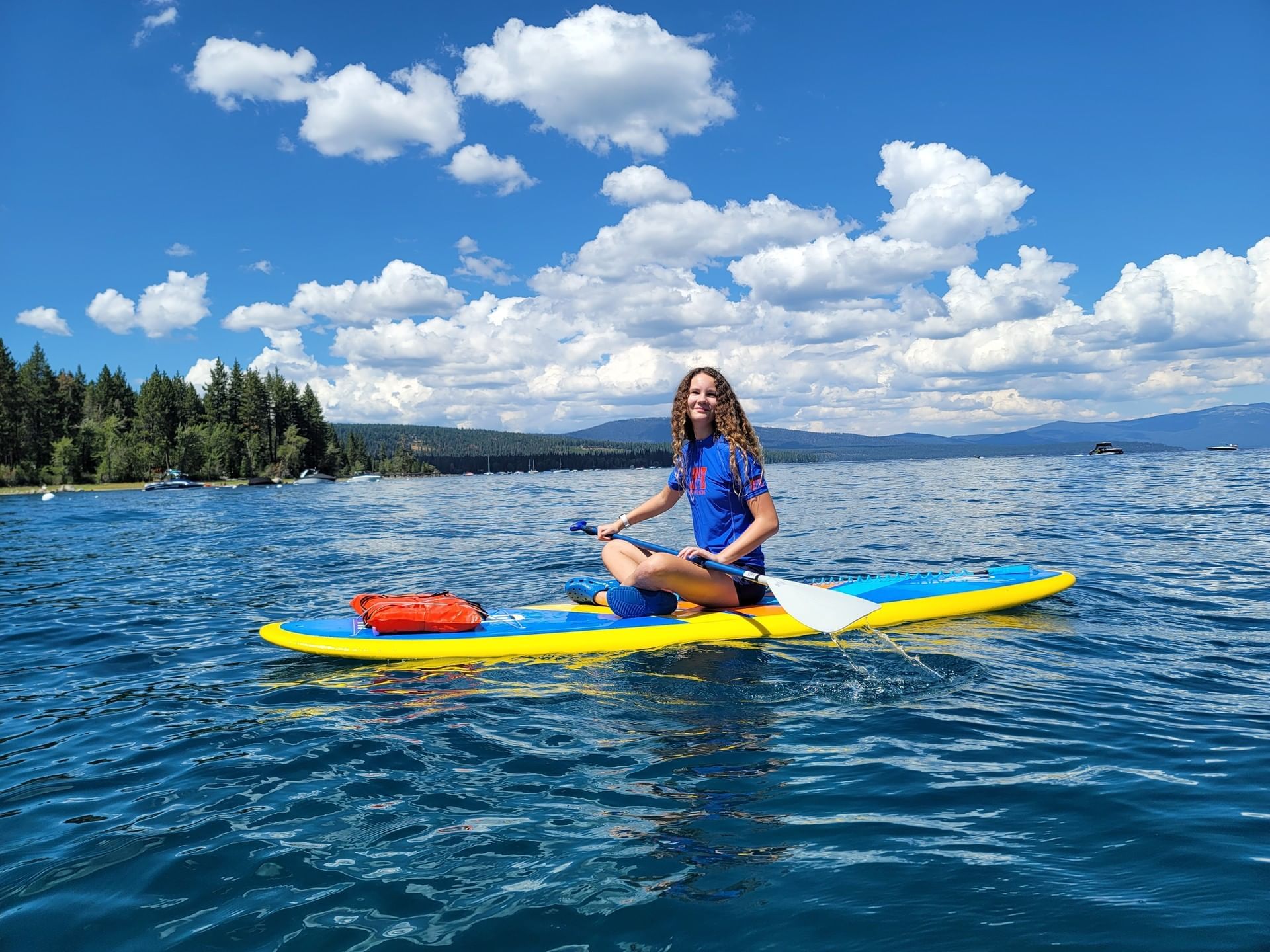 A woman riding a kayak in the lake near Granlibakken Tahoe