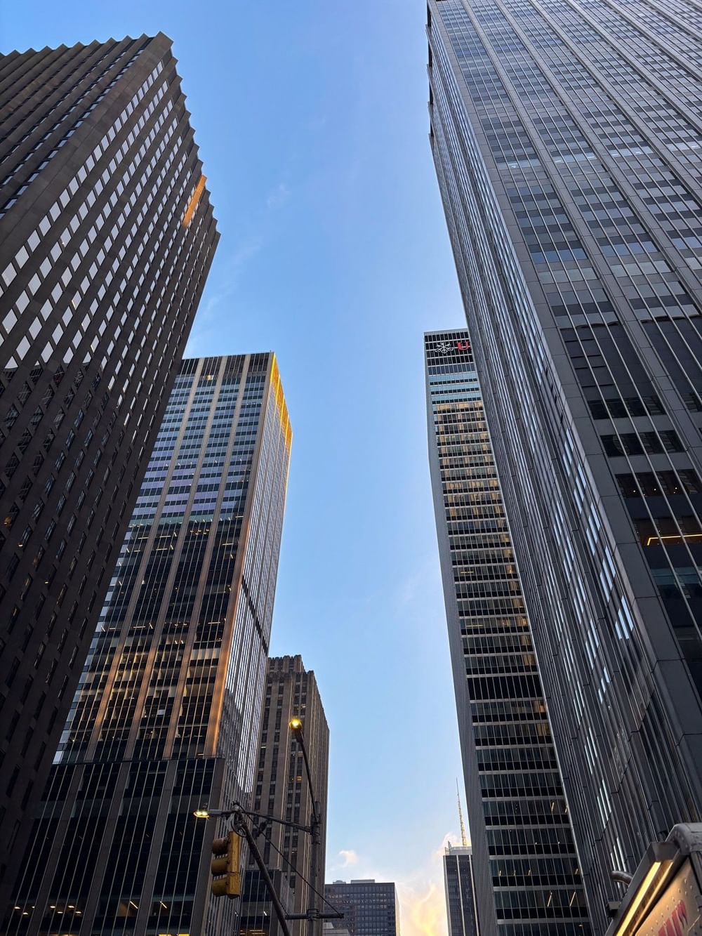 Looking up at towering Midtown Manhattan skyscrapers at Warwick New York hotel entrance