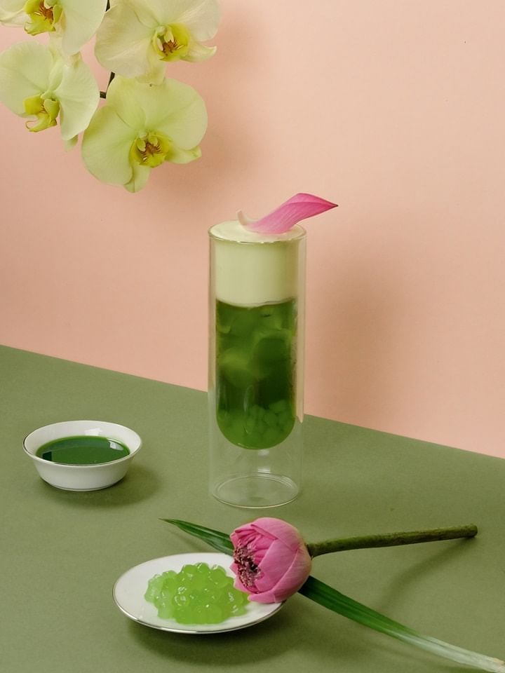 Glass cylinder filled with green jelly, topped with cream and a pink petal in Park Lounge at Park Hyatt Saigon