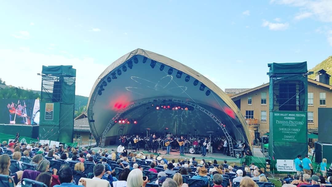 Crowded summer concert with a shark looking stage near The Chateaux Deer Valley