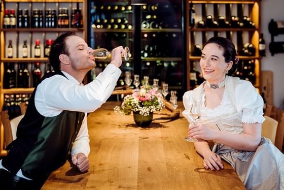 A couple drinking wine at a bar in Schloss Hotel Pichlarn