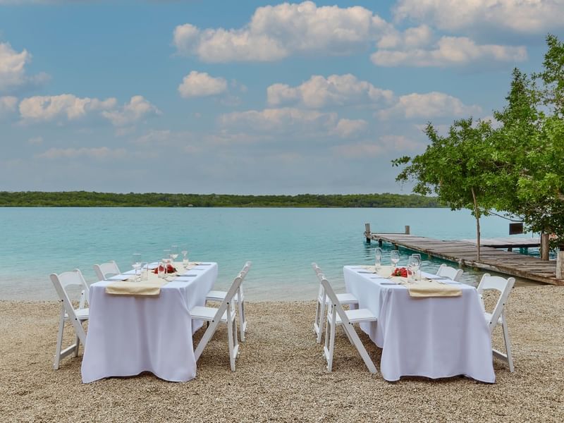 Dining tables arranged for a private event overlooking the lagoon at The Explorean Resorts