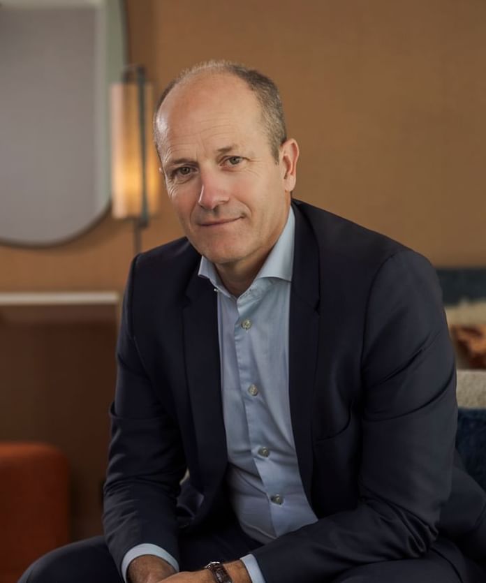 Portrait of a gentleman in a suit posing on a lounge at Oceania Hotels