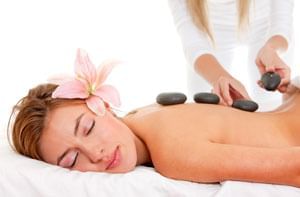 Lady having a hot stone treatment in Reflection Spa & Salon at Lake Buena Vista Resort Village & Spa