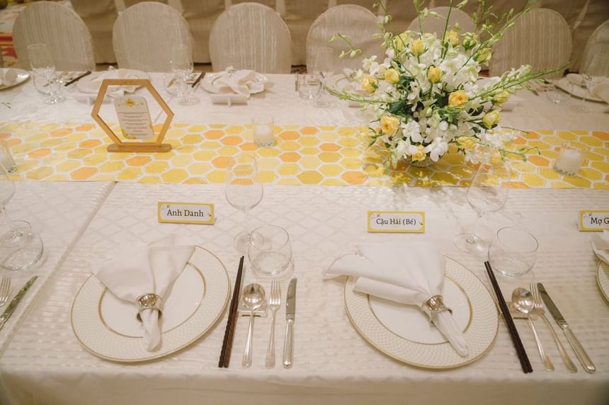 Beautifully arranged dining table with elegant white napkins, crystal glasses, and floral centerpieces at Park Hyatt Saigon