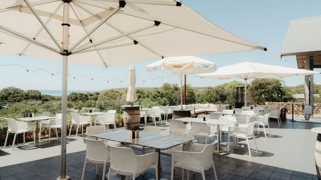 Outdoor terrace with white tables and chairs under umbrellas overlooking green landscape for Pair'd Margaret River Region 2026