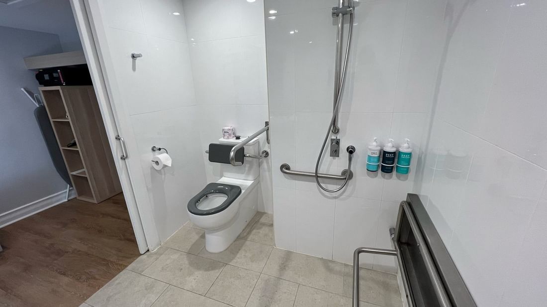 Accessible bathroom with grab rails, handheld shower, and toilet in an accessible classic room at Novotel Sunshine Coast.