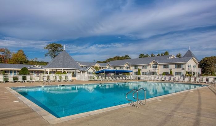 Sunbeds by the outdoor pool area on a sunny day at Ogunquit Collection