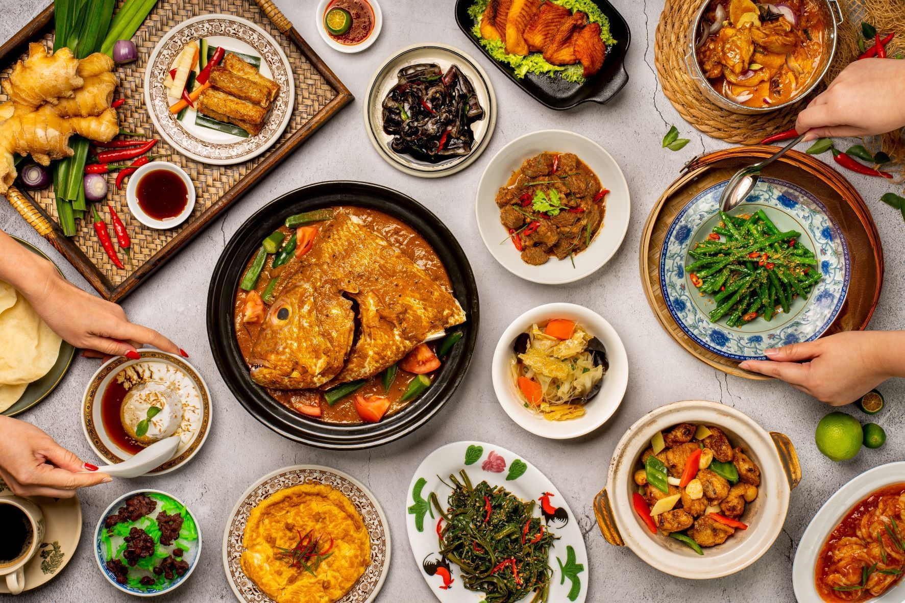 Image 47: Top view of Asian dishes on a table with hands serving food in White Rose Café at York Hotel Singapore