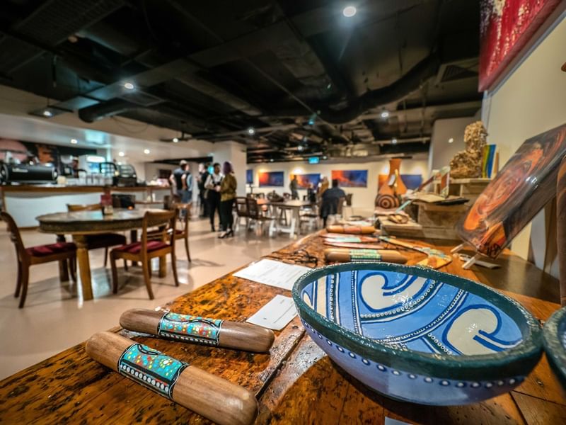 Artisan crafts on a wooden table in Birrunga Gallery & Dining with visitors near Sofitel Brisbane Central
