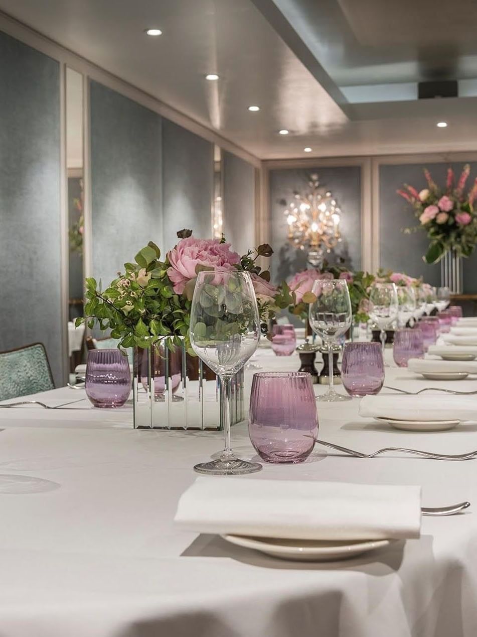 Dining setup featuring glass tumblers by floral arrangements in Eaton Suite at The Capital Hotel, Apartments and Townhouse