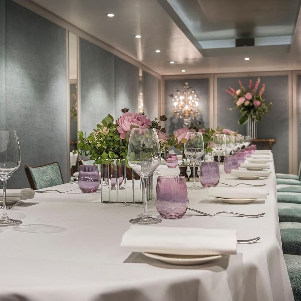 Dining setup featuring glass tumblers by floral arrangements in Eaton Suite at The Capital Hotel, Apartments and Townhouse