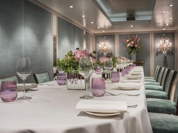 Dining setup featuring glass tumblers by floral arrangements in Eaton Suite at The Capital Hotel, Apartments and Townhouse