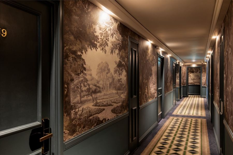 The Capital Hotel, Apartments and Townhouse corridor with patterned floor runners and doors under scenic wall murals
