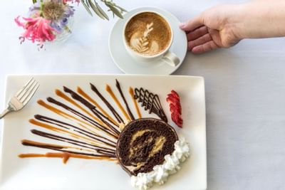 A piece of swiss cake with a coffee at Heritage House Resort