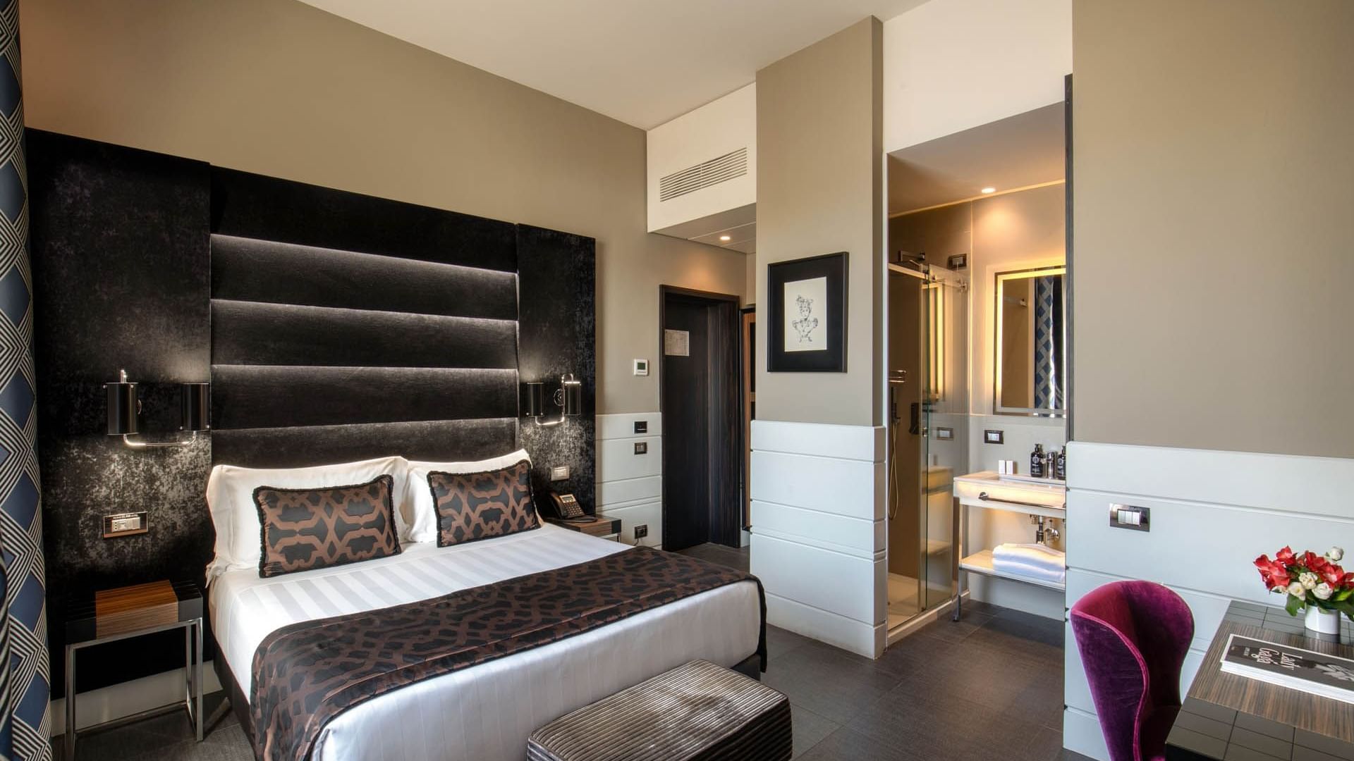 Bed with ottoman and work desk beside in Classic Room at The Glam Hotel