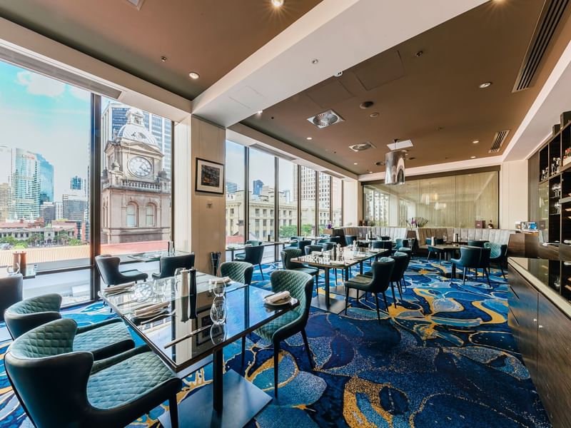 PRIVÉ dining room with floor-to-ceiling windows overlooking historic Brisbane architecture at Sofitel Brisbane Central
