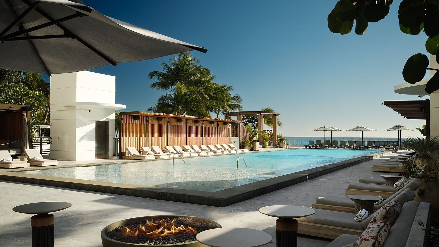 Luxe infinity pool with sweeping ocean views and poolside lounge chairs.