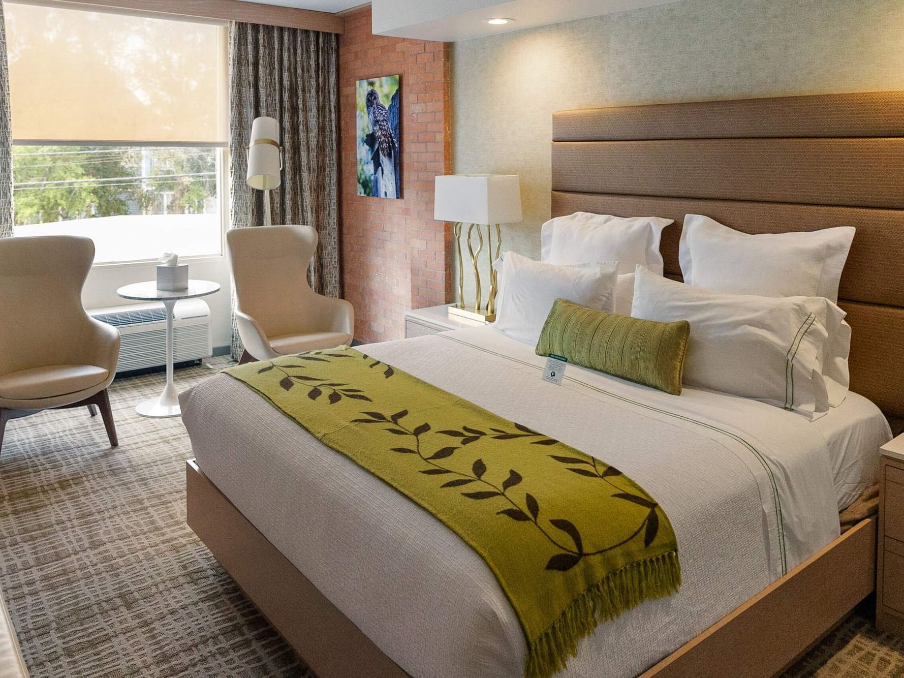 Bed with side tables and a sitting area by the window in Superior King at The Fredonia Hotel