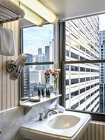 Elegant bathroom with city skyline view from the window in Superior Suite at Warwick Allerton Chicago