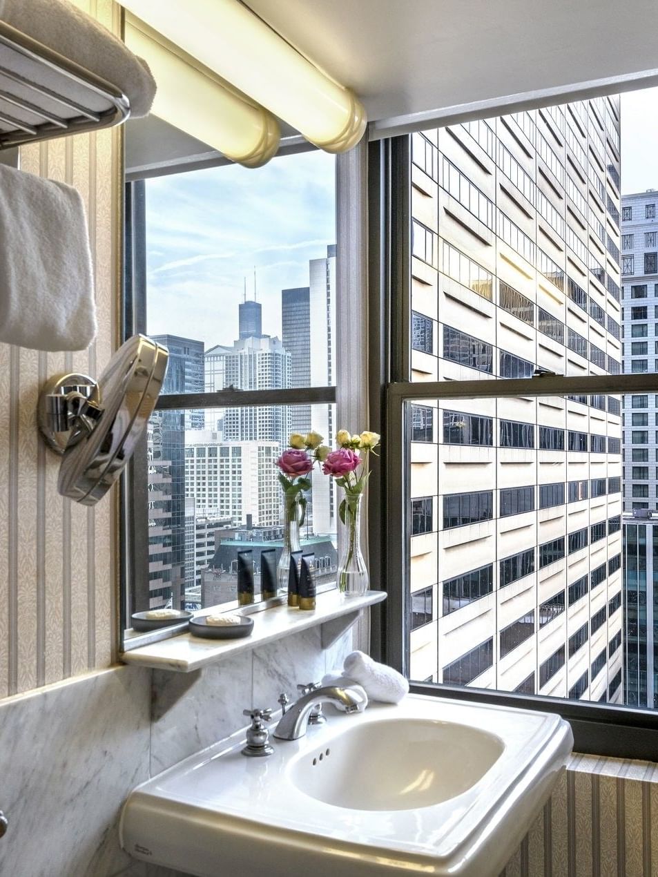 Elegant bathroom with city skyline view from the window in Superior Suite at Warwick Allerton - Chicago.