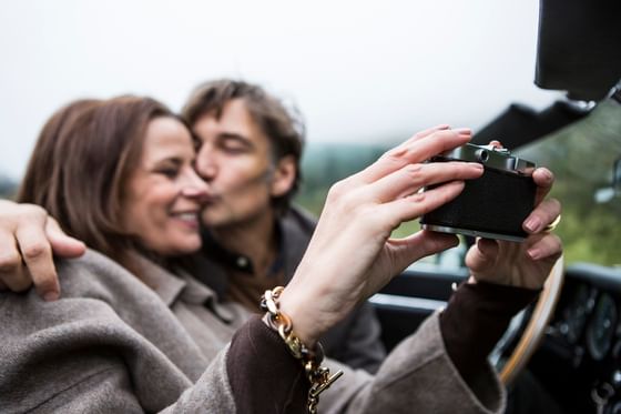 A lovely couple taking a photo while kissing near Liebes Flueh