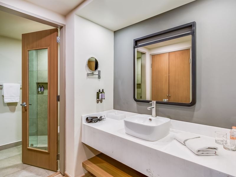 Bathroom with vanity area with amenities, towels and door opened to shower area in Room with a View, 2 Double at Fiesta Inn
