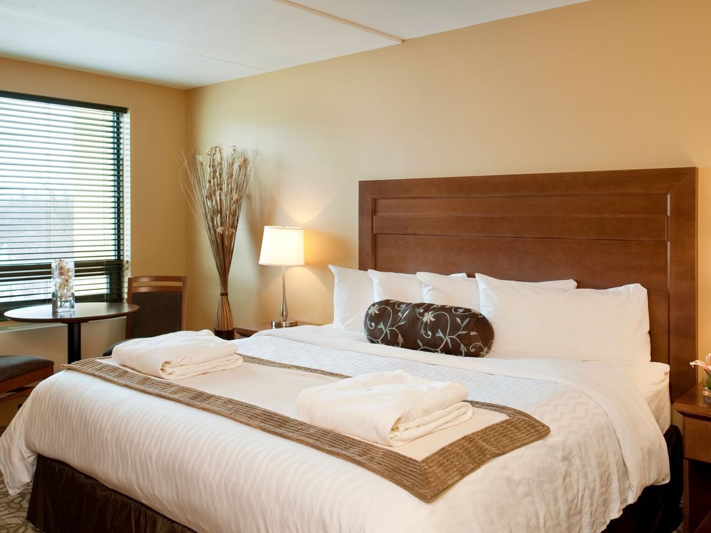 Cozy bed by the window with a nightstand in Standard King Bed at Temple Gardens Hotel & Spa
