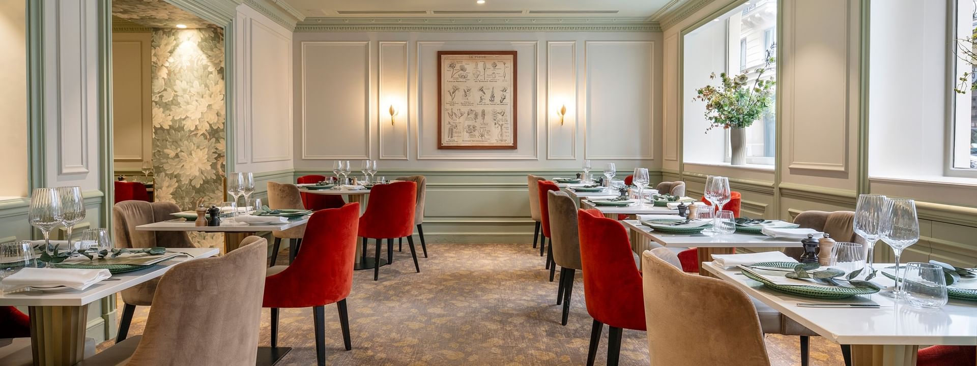 Dining room featuring tables surrounded by red and beige velvet chairs in Le Céladon at Hotel Westminster Paris