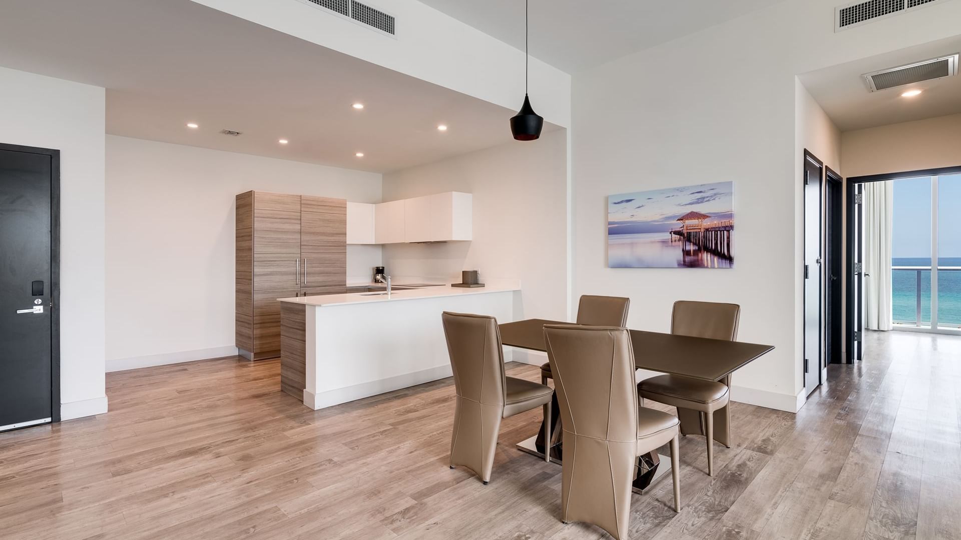 A modern dining area with a kitchenette and ocean view