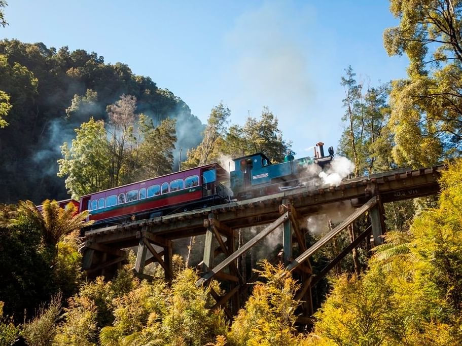 A train running on a bridge near the Strahan Village Hotel