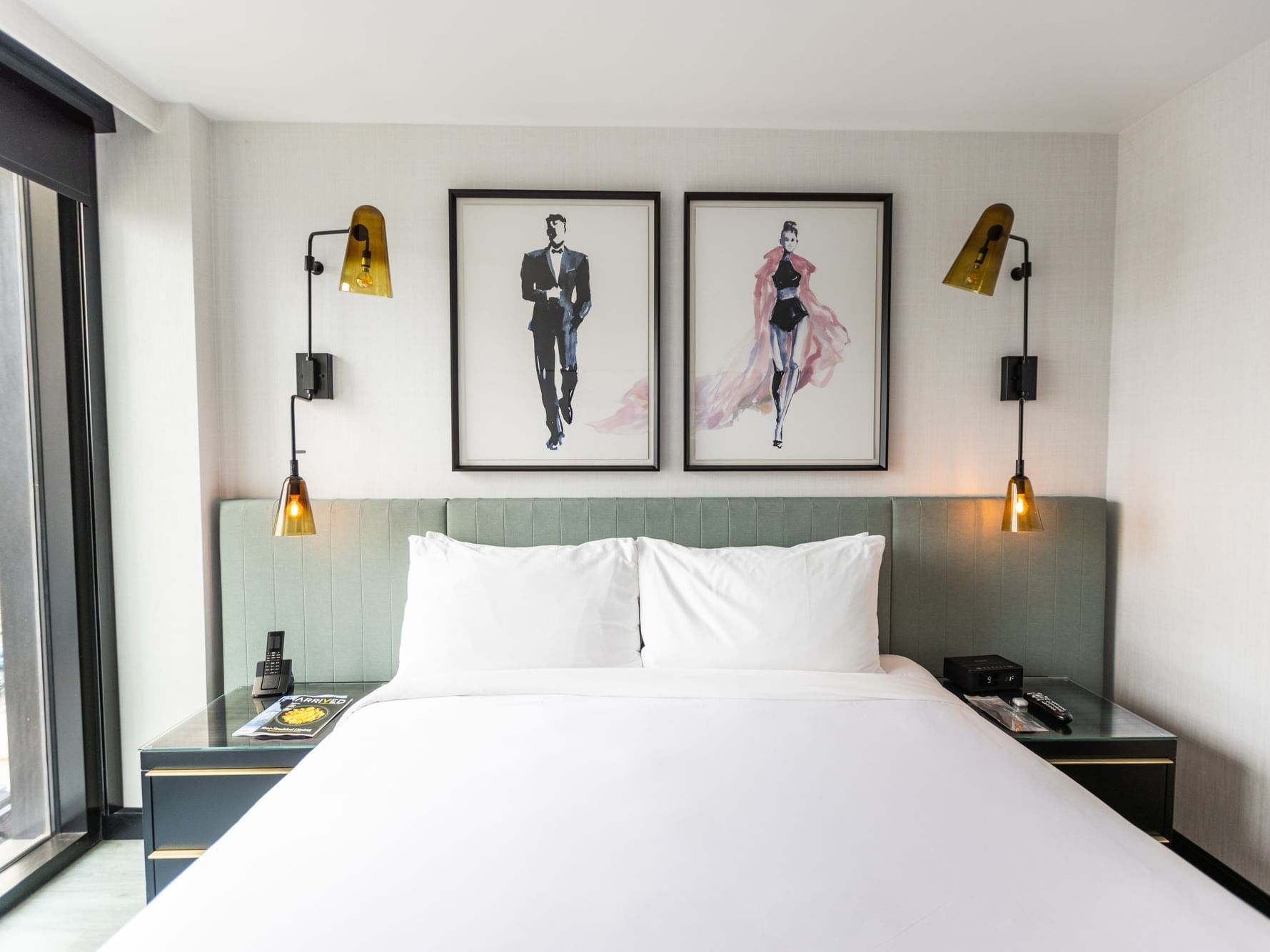 Modern guest room with a clean white bed, gold lamps, and large wall art at The Godfrey Hotel Hollywood