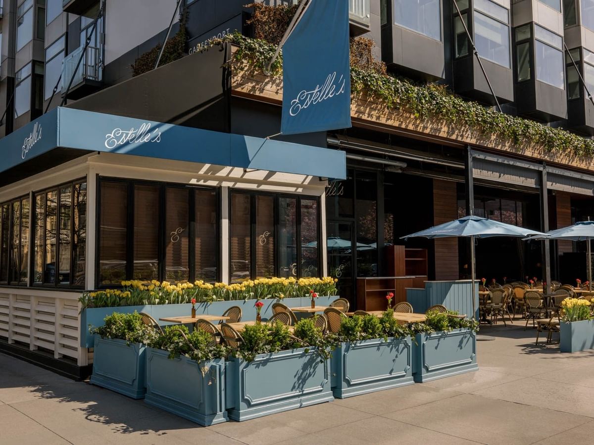 Estelle's outdoor patio with blue awnings and yellow flower planters at Gansevoort Meatpacking NYC - NEW