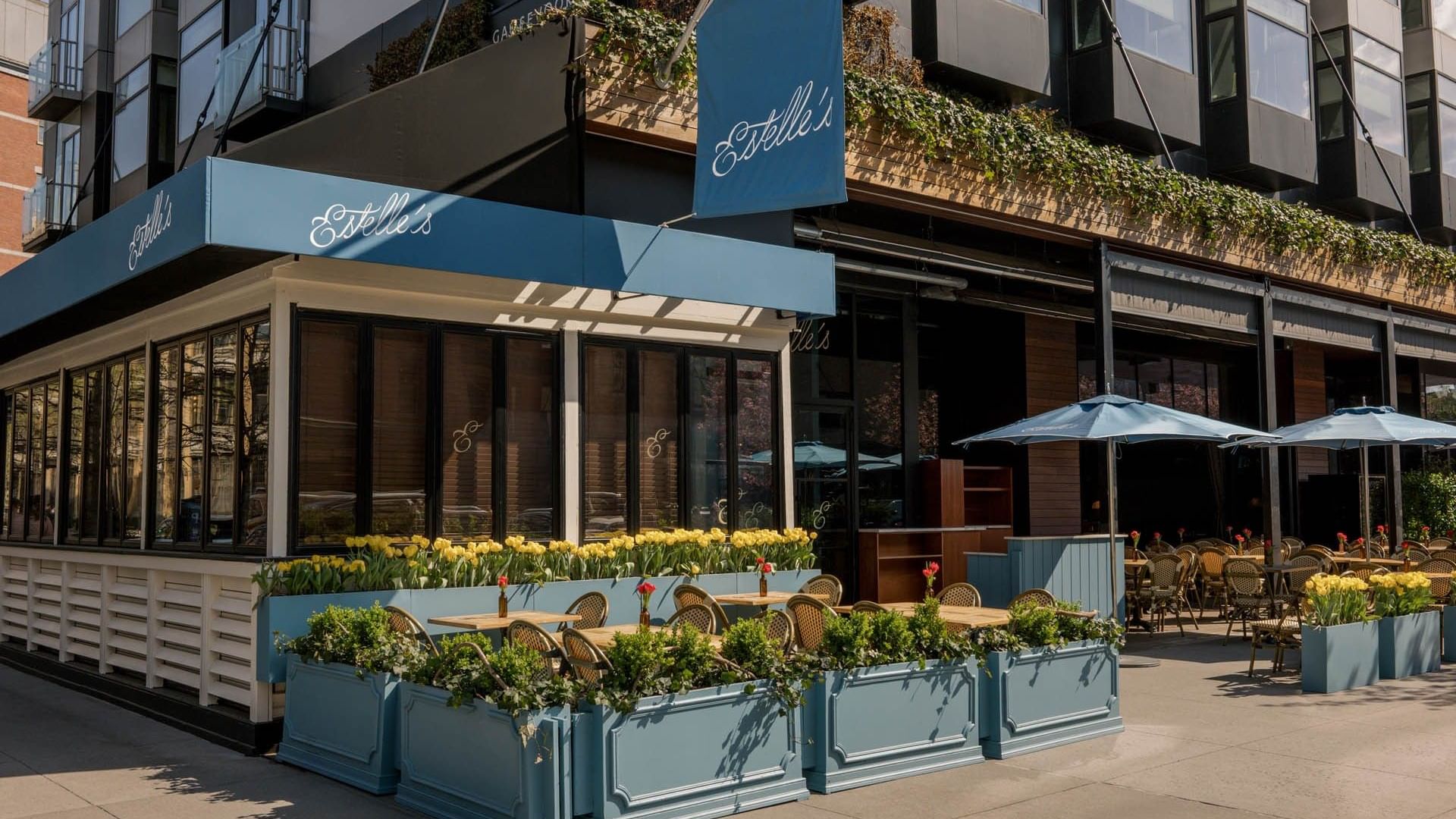 Estelle's outdoor patio with blue awnings and yellow flower planters at Gansevoort Meatpacking NYC - NEW