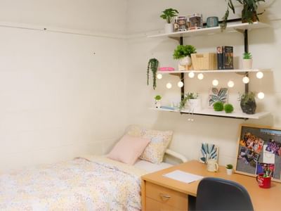 Cozy single room with desk and shelving at La Trobe University Units.