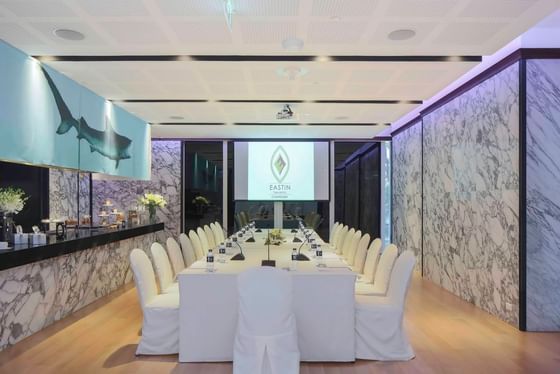 Conference set-up in a meeting room with marble wall and projector at Eastin Tan Hotel Chiang Mai