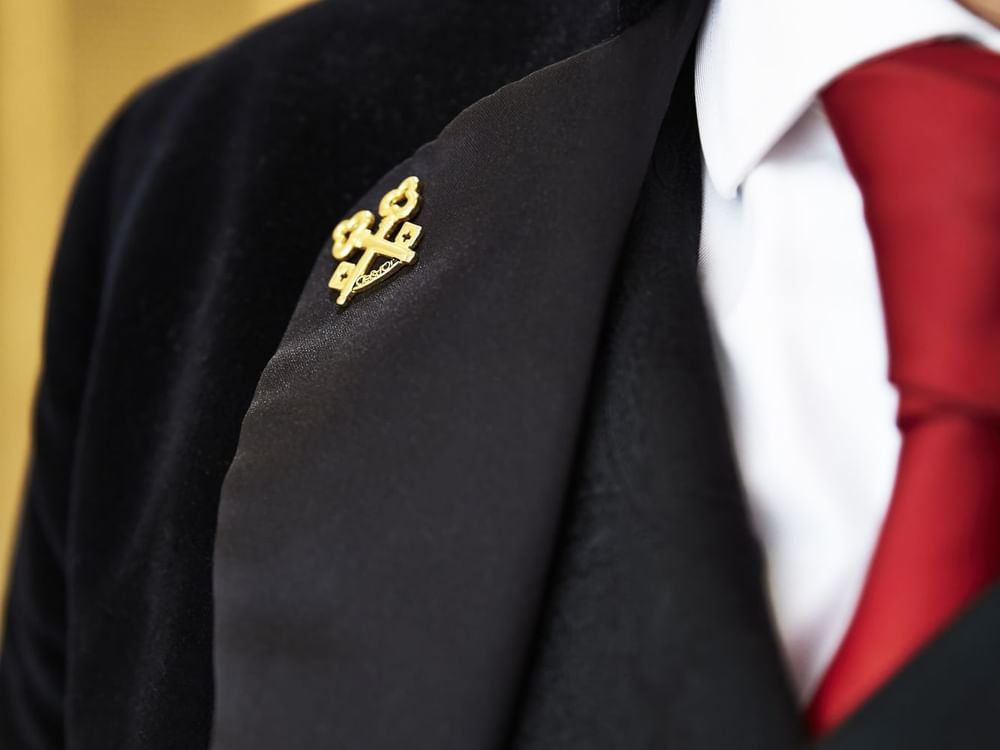 Close-up of the concierges blazer gold pin at Kempinski Hotel Cancún