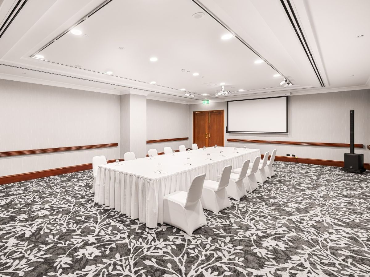 Duxton 3 & Duxton 4 conference room featuring a long table set with chairs, and projector screen at Duxton Hotel Perth