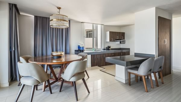 Penthouse featuring a kitchen, dining area with a round wooden table, and grey chairs at Sunvivia Mazatlán