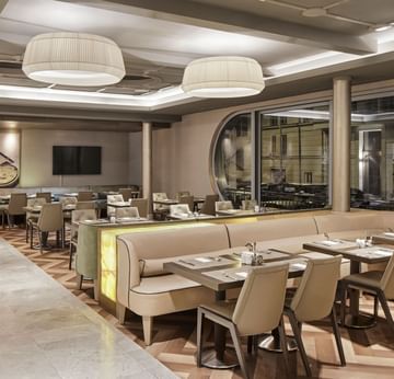 Elegant interior of Breakfast Restaurant with tables and chairs at Titanic Comfort Mitte