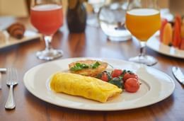 Huevo y fresas servidos en un plato con jugo de fruta en One Hotels