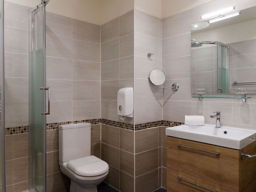 Bathroom shower & vanity area in a room at Hotel du Parc