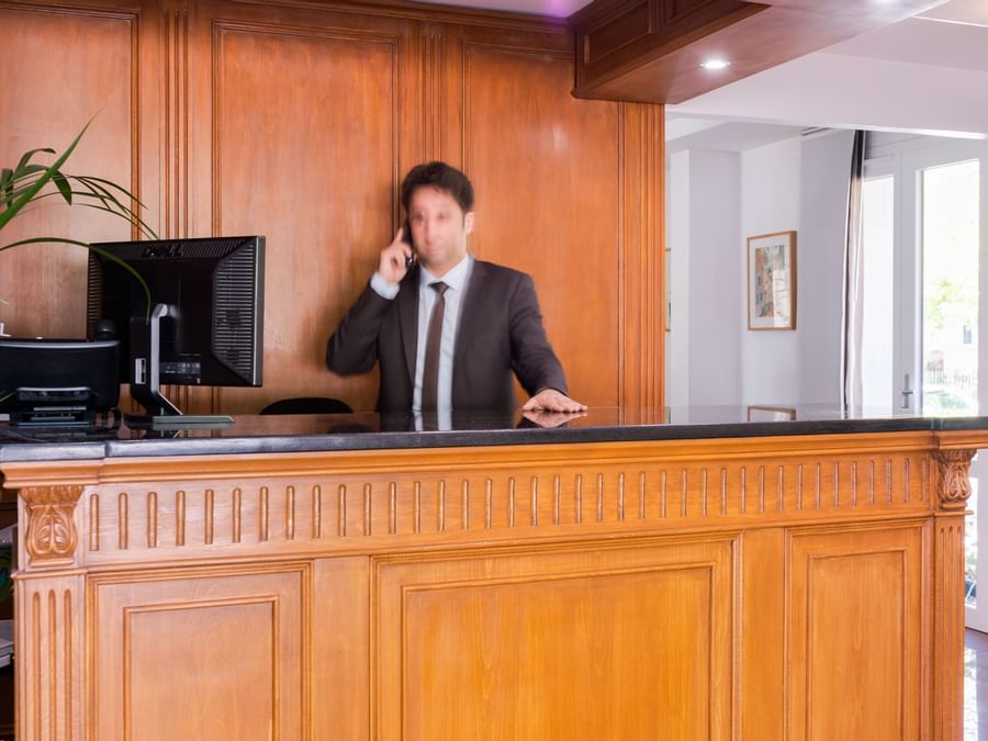 A receptionist at the reception desk in Hotel Paris Sud