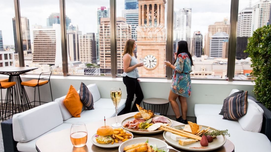 Ladies enjoying drinks & snacks in Sixteen Antler's Brisbane Rooftop Bar at Pullman King George Square