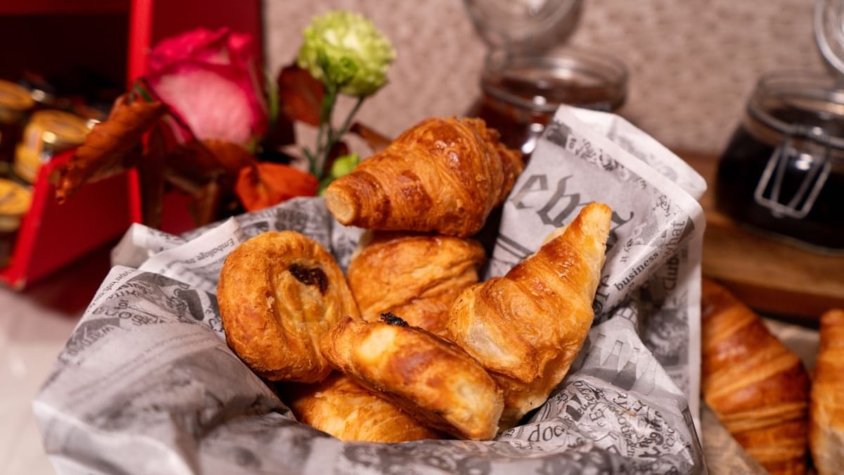 Basket of fresh croissants and pastries with flowers in Restaurant Le W at Warwick Paris Champs Elysées