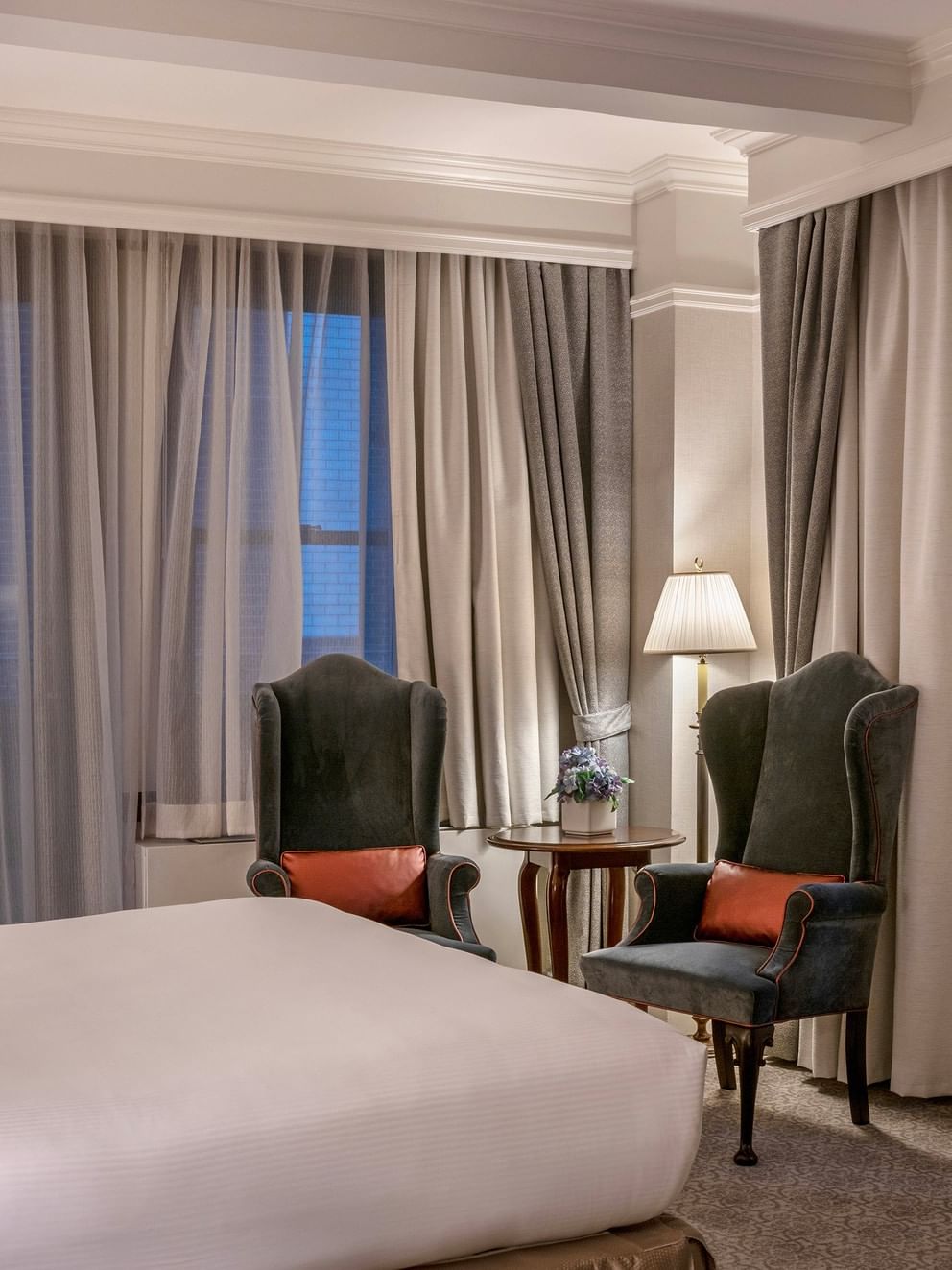 54th Suite with a king bed and chairs near the window at Warwick New York